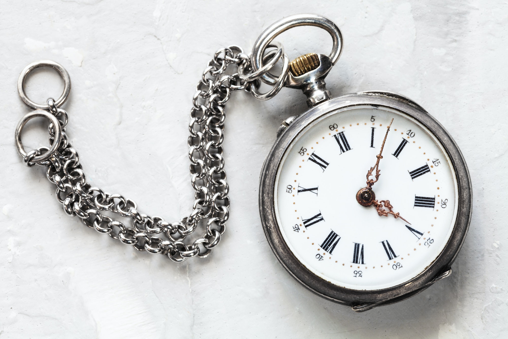 retro pocket watch with chain on white plaster